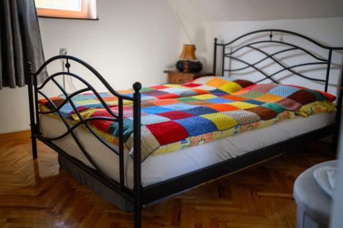 a bed with a colorful quilt on it in a room at Kuća Sokolovića in Zaječar