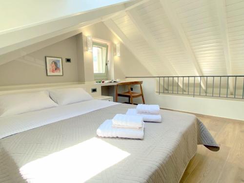 a bedroom with a white bed with towels on it at Metropolis Nextdoor in Vathi