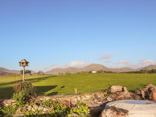 a garden with a view of a field and mountains at The Peacock Roost - Uk46297 in Brynkir
