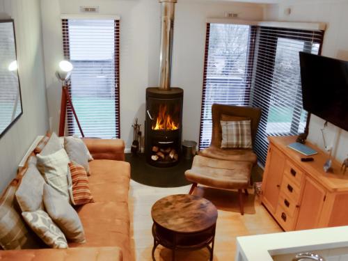 a living room with a couch and a fireplace at The Wooden Lodge in Byton