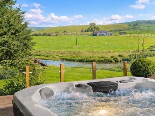 a bath tub with a view of a field at Harperfield Chalet in Lanark