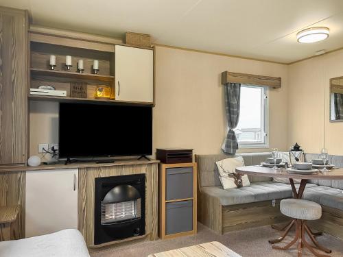 a living room with a tv and a fireplace at Kjs Holiday Haven in Ayr
