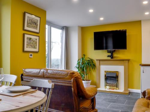 a living room with a couch and a fireplace at Dutch Barn One - Uk12872 in Brynkir
