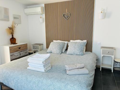 a bedroom with a bed with towels on it at Échappée Mistral - Jacuzzi Privé & Brasero in Eyragues