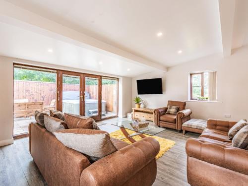 a living room with two couches and a tv at Stuarts Farm Barn in Westhead