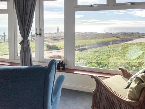 a living room with a view of the ocean through a window at Lloyds Cottage in Southwell