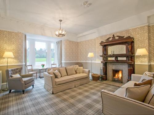 a living room with a couch and a fireplace at Potarch Lodge in Kincardine OʼNeil