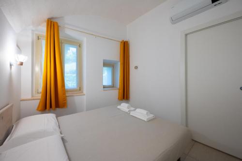 a bedroom with two beds and an orange curtain at Predore Lake View Suites in Predore