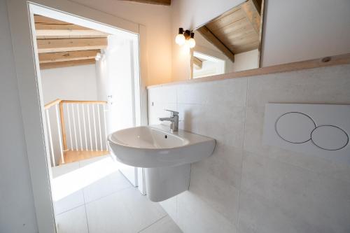 a white bathroom with a sink and a mirror at Predore Lake View Suites in Predore