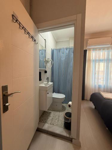 a bathroom with a toilet and a sink at Olivento Pansiyon in Ayvalık
