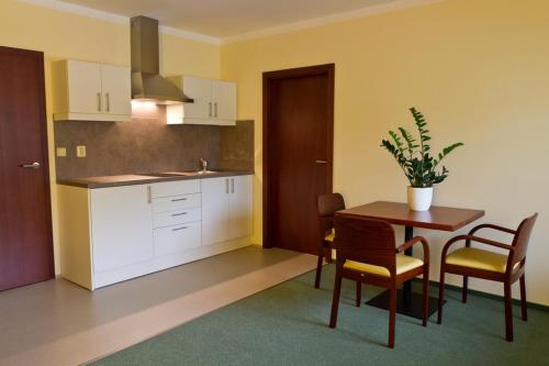 a kitchen with a table and a table and chairs at Hotel Hermes in Krnov