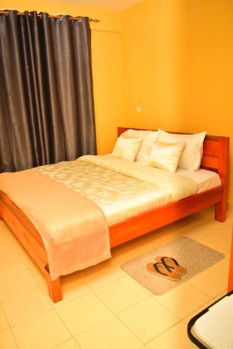 a bedroom with a bed with a black curtain at Hecahomes in Kericho