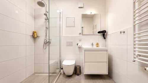 a white bathroom with a shower and a toilet at URBAN FLATS Berlin in Berlin