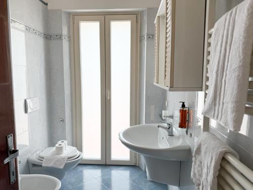 a white bathroom with a sink and a toilet at Cuore di Nozzano Castello in Lucca