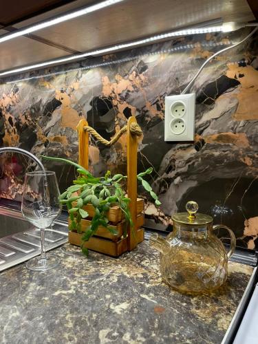 a table with a glass vase and a plant on it at Piitota in Almaty