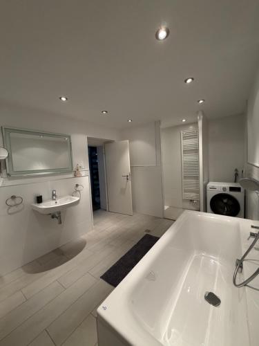 a large white bathroom with a tub and a sink at Wunderschöne 2 Zimmer Wohnung in Wuppertal in Wuppertal