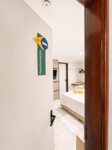 a room with a bed and a sign on the wall at Hotel Nacional Arapiraca in Arapiraca