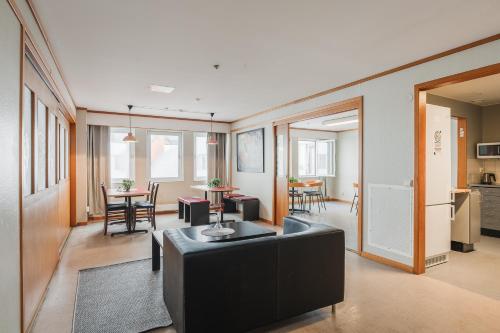 ein Wohnzimmer mit schwarzem Sofa und einem Tisch in der Unterkunft 2Home Stockholm South in Stockholm