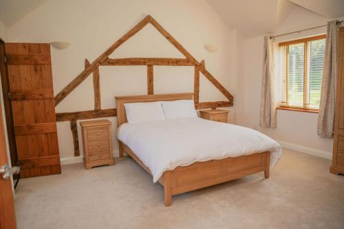 a bedroom with a large bed with a wooden frame at Ceunant in Llanfair Caereinion