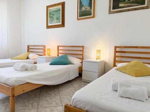 a room with two beds and two night stands at Cuore di Nozzano Castello in Lucca