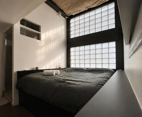 a bed in a room with a large window at Le miroir secret in Anglet