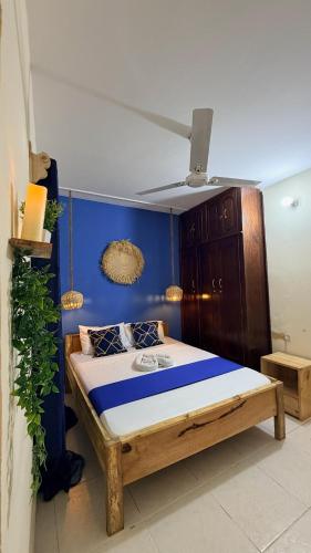 a bedroom with a bed with a blue wall at Golden Nap hostel in Zanzibar City