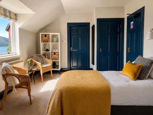 a bedroom with blue doors and a bed with a yellow blanket at Ardvreck House in Ullapool