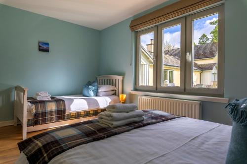 a bedroom with two beds and a window at Loch Ness Abbey Cottages in Fort Augustus