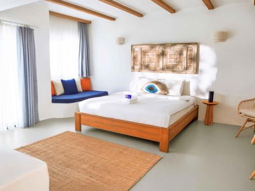 a bedroom with a large bed and a blue chair at Kassandra Oludeniz in Oludeniz