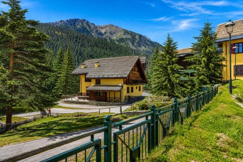 a house in the mountains with a fence at Hostdomus - Chalet Claviere in Claviere