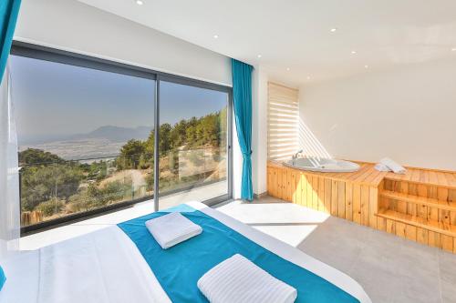 a bedroom with a bed and a large window at SHB Villas Kalkan in Kaş
