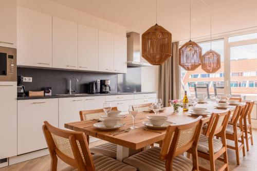 a kitchen with a long wooden table and chairs at Summio Parc Aquadelta in Bruinisse