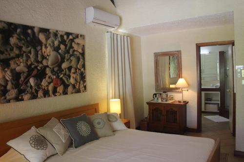 a bedroom with a bed with a large painting on the wall at Fantastic spacious beachfront VILLAVACANCES in Grand-Baie