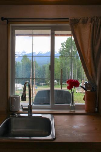 a kitchen sink and a window with a view of a mountain at Goonieland Backcountry Sauna & Stays in Golden
