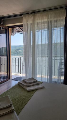 a bedroom with a bed with a large window at Casa Aless Eselnita Adults Only 14 plus in Eşelniţa