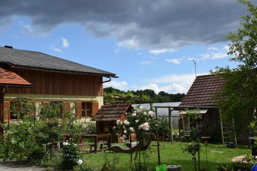 a yard with two houses and a garden with flowers at Bauernhof Flucher-Plaschg in Straden