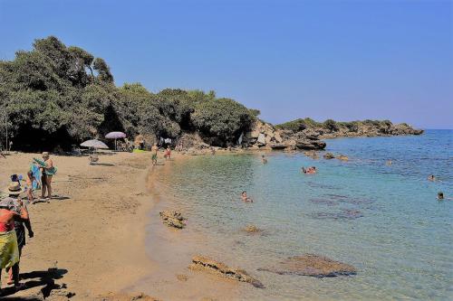 a group of people on a beach in the water at Sea Breeze Apartment in Korakokhórion