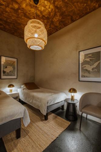 a bedroom with two beds and a chandelier at Buntes nams l Self check-in l Private entrance in Limbaži