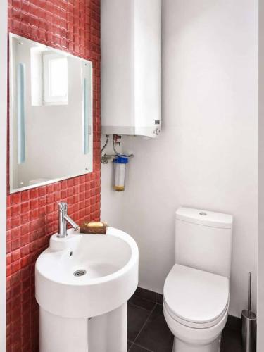a bathroom with a white toilet and a sink at Sunny House Seaside in Zatoka