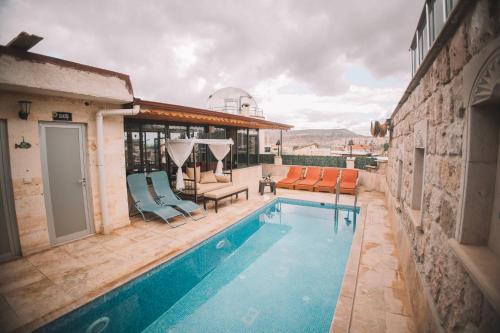 a swimming pool with two chairs and a table at Balloon Cave Hotel in Göreme
