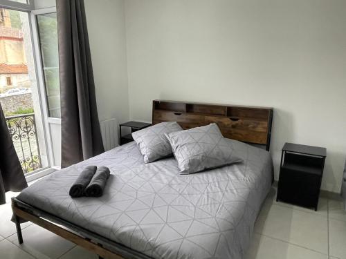 a bedroom with a bed with two pillows and a window at Entre Rivière et Sommets in Seix