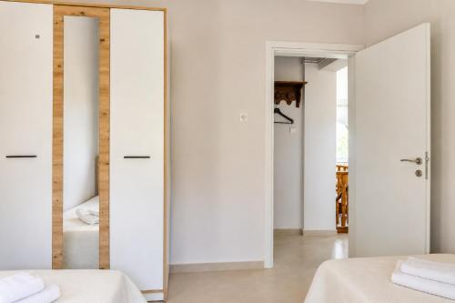 a bedroom with two beds and a mirror at Villa LaThea in Akti Salonikiou