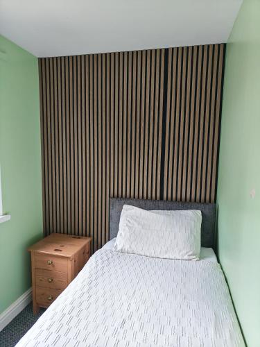 a bedroom with a bed with a wooden headboard at Hayle holiday cottage in Hayle