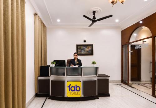 a woman sitting at a reception desk in a hotel lobby at FabHotel The Arjun Sushant lok - Iffco Chowk Sector 29 in Gurgaon