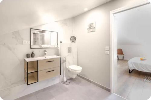 a white bathroom with a toilet and a sink at Chambre Attrape rêves in Sainte-Geneviève-des-Bois