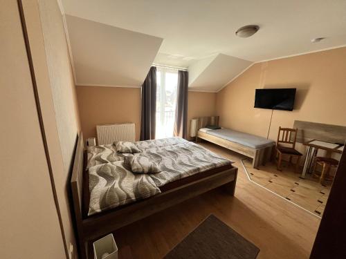 a bedroom with a bed and a window and a desk at Adrienn Apartman in Sárvár