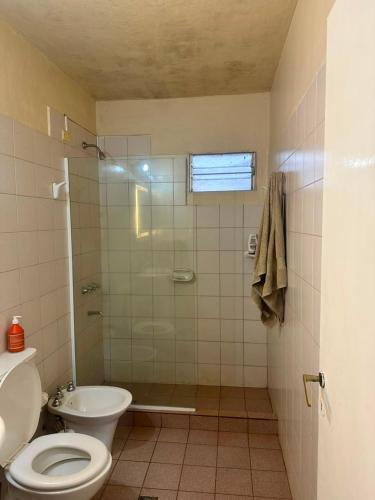 a bathroom with a toilet and a glass shower at Marisol in Apóstoles