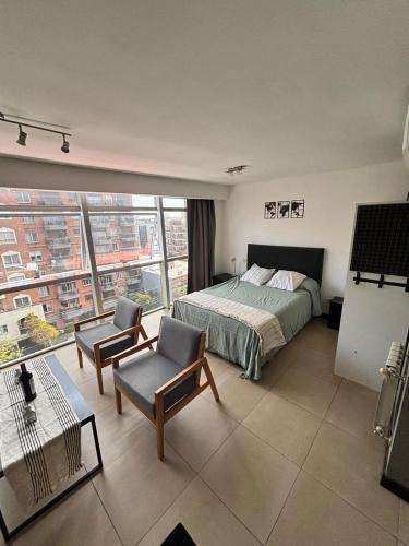 a bedroom with a bed and a large window at monoambiente castelar in Castelar