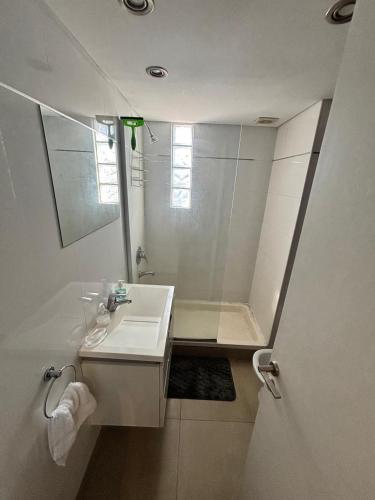 a white bathroom with a sink and a shower at monoambiente castelar in Castelar