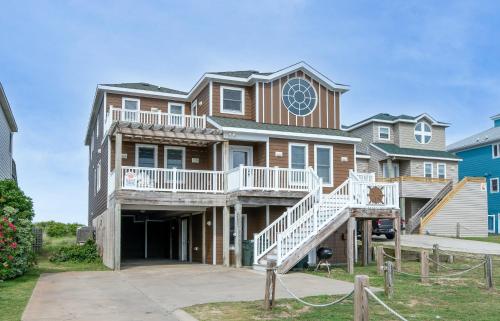 a large house with a staircase in front of it at Dream Catcher - Nags Head MP 12, Oceanfront, Elevator, Pool, Hot Tub, Pets OK, YR Flex in Nags Head